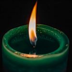 Green Candle Lit In Darkness