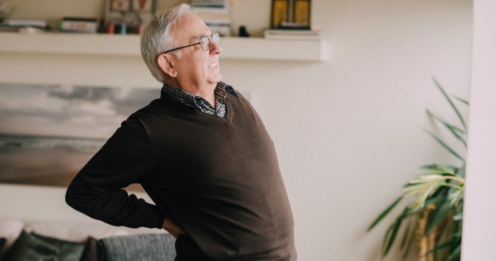 Senior Man in Living Room Experiencing Back Pain
