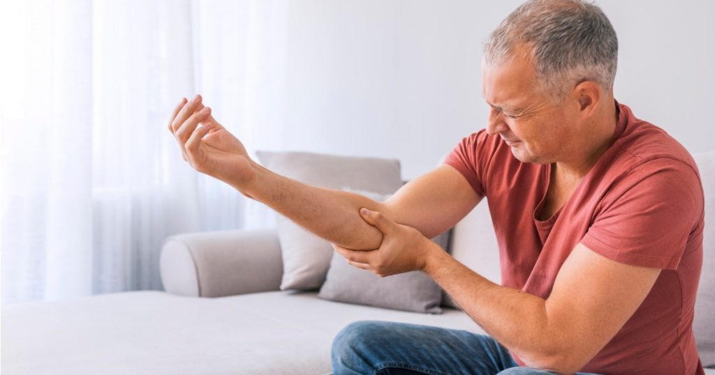 Man Experiencing Pain When Bending Arm